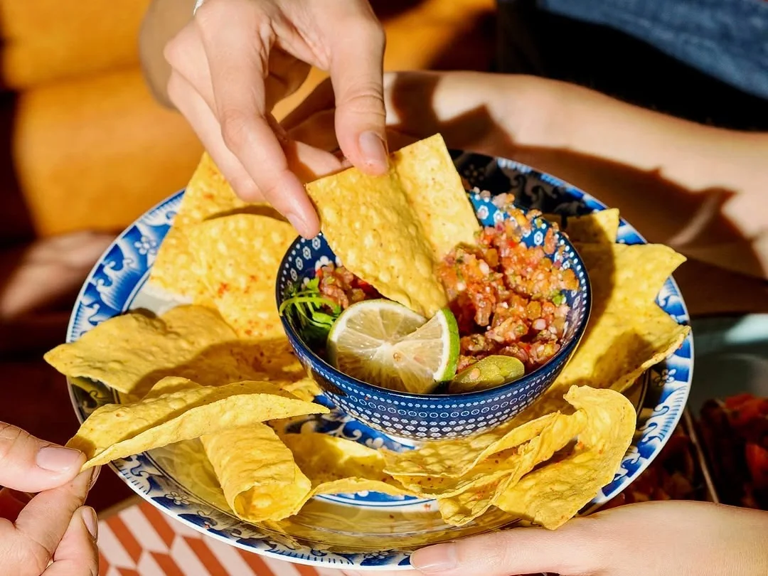 Chips dipped into salsa at MamaMita.