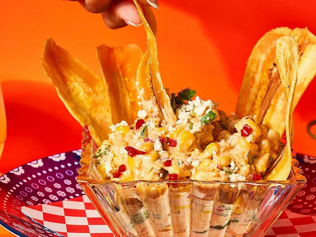 A bright elote and chips dish served at MamaMita.