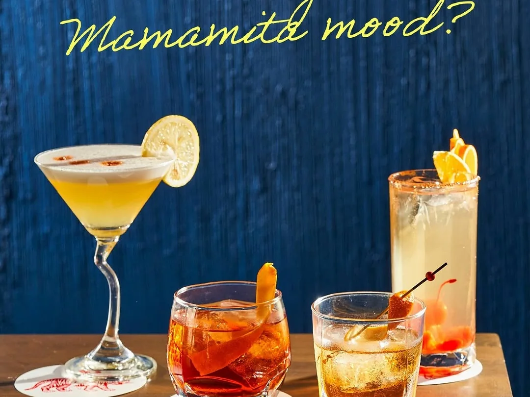 Cocktails arranged against a blue MamaMita wall.